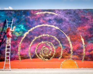 woman creating colorful mural, photo by Rosie Kerr